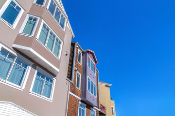 View of houses' exterior from below against the clear blue sky in San Francisco, CA