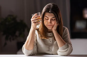 Fotobehang alcoholism, alcohol addiction and people concept - drunk woman or female alcoholic drinking whiskey at home © Syda Productions