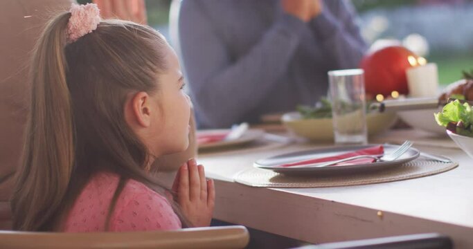 Video of happy caucasian daughter saying grace at table before family meal