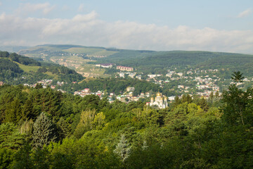 Fototapeta premium Panoramic view of the green valley among the hills and the horizon with a cloudy sky and a space to copy from the observation deck of Kislovodsk russia
