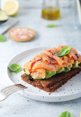 A rye bread sandwich with avocado and salmon