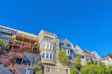 Facade of four-storey houses with stairs at the entrance and balconies in San Francisco, CA