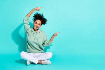 Full length photo of charming excited lady wear sweatshirt pointing fingers empty space isolated turquoise color background