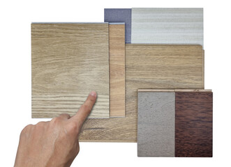 architect's hand choosing interior material samples including vinyl floorings, engineered floorings, fabric interior wallpapers isolated on white background with clipping path. mood and tone board.