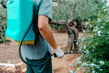 man spraying insecticide from a knapsack sprayer