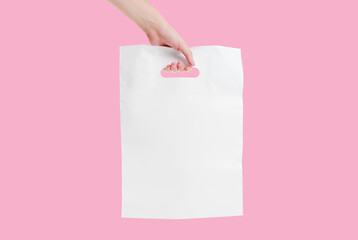 Hand carrying a white plastic bag