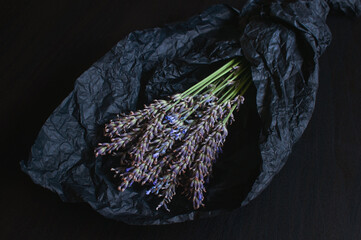 Bouquet of fragrant fresh lavender flowers on black crumpled wrapping paper