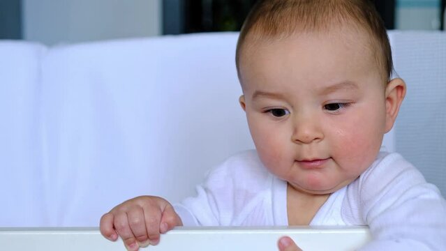 Cute portrait of a baby in a crib close-up. A child in white clothes on white underwear. Tenderness and care, children's problems.