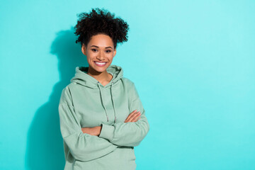 Portrait of cheerful charming lady crossed arms toothy smile empty space isolated on turquoise color background