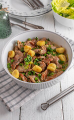 Pork fillet with cream sauce, green peas and potato gnocchi