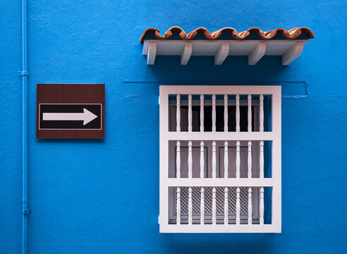 Ventana y cartel en una fachada de Cartagena, Colombia.