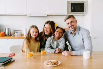 Happy smiling family sitting at the kitchen table at home