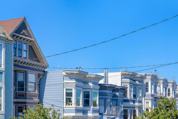 Obraz na płótnie Canvas Adjacent residential buildings with victorian style against the clear sky in San Francisco, CA