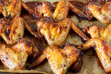 Roasted chicken wings on baking tray  background, ready to eat