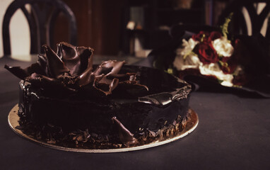 birthday chocolate cake with flowers in the background