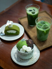 parfait,matcha green tea roll sweet japanese dessert with green tea milk matcha on wooden table in minimal japanese style cafe