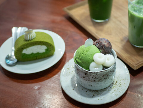 Parfait And Matcha Green Tea Roll Sweet Japanese Dessert On Wooden Table In Minimal Japanese Style Cafe