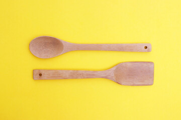 A set of bamboo dishes on a bright yellow background.