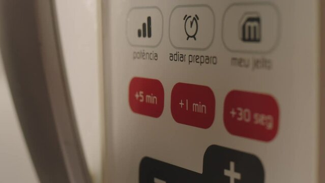 close on microwave, finger selecting plus one minute, handheld camera, slow motion in alexa mini