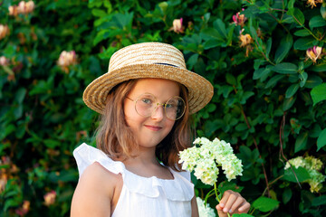 outdoor portrait of cute little girl in straw hat