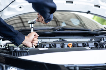 Close-up of a mechanic using a wrench to perform engine maintenance.