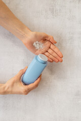 Woman applying baby talcum powder on hand. Skin care cosmetic