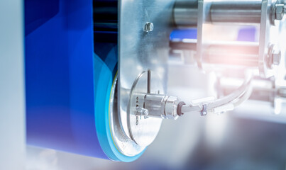 Selective focus on drum motor with blur blue conveyer belt. Electric motor in food factory....