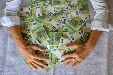 woman embracing pile of 100 Euro bank notes