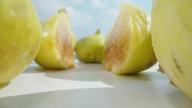 A green fig, cut in half, the camera passes through it. Dolly slider extreme close-up.