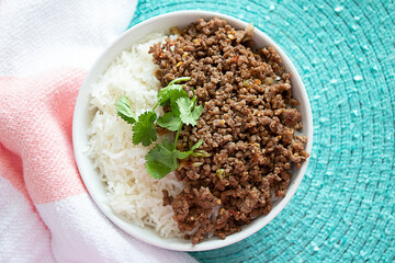 A bowl of Jasmine rice and caramelized ground beef topped with fresh cilantro.