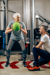 Senior Woman Doing Workout With Coach In The Gym