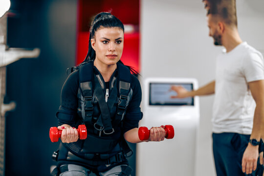Woman Doing EMS Workout With Personal Trainer In The Gym