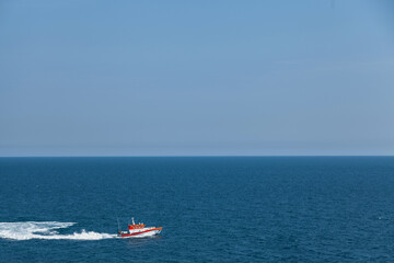 Search and rescue boat floats on the waves at speed. The horizon is visible in the distance. Sky...