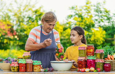 Women with jar preserved vegetables for the winter mother and daughter. Selective focus.