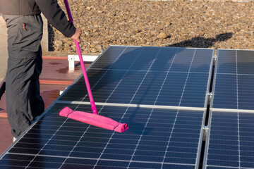 Close up view of face less worker cleaning the solar panels farm