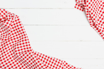 Top view fabric tablecloth on old white wood background. Red and white crumpled clothes on white background for a menu of a restaurant with copy space.