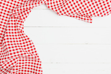 Red and white crumpled clothes on white background for a menu of a restaurant with copy space. Top view fabric tablecloth on old white wood background.