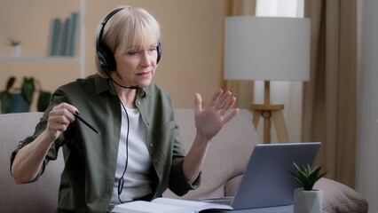 Portrait mature female in headset teacher online mentor business trainer psychologist talk in...