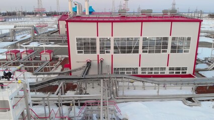 Drone flies over the plant in winter, petrochemical plant aerial view of the pipes and tanks for storing and cleaning oil and gas. Industrial buildings in winter. Fuel crisis in winter.