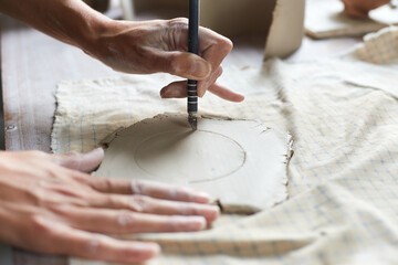 Female ceramist working in pottery studio. Ceramist's Hands Dirty Of Clay. Process of creating pottery. Master ceramist works in her studio