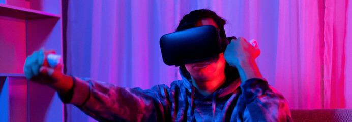Man wears virtual reality glasses and uses joystick to play games with fun, VR, Future games,...