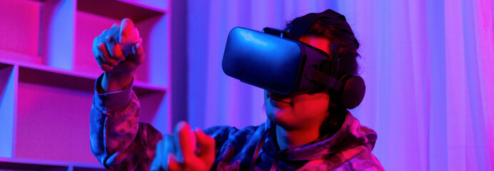 Man wears virtual reality glasses and uses joystick to play games with fun, VR, Future games, Technology, Red and blue background, Touch Controller, Bluetooth Remote Controller, VR game concept.