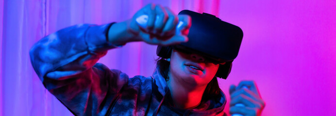 Man wears virtual reality glasses and uses joystick to play games with fun, VR, Future games, Technology, Red and blue background, Touch Controller, Bluetooth Remote Controller, VR game concept.