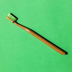 green toothbrush on light green background