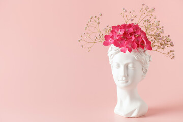 Creative art concept plaster head ancient sculpture with hair fresh flowers gypsophila and...