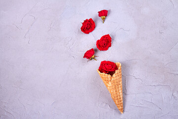 Waffle ice cream cone with rose flowers. Top view flat lay.