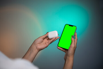 Modern wireless headphone and gadget with green screen. 