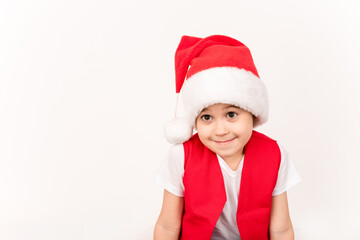 Portrait of smiling beautiful child in red Santa Claus hat isolated on white background. 5 year happy little European boy. Banner. Copy space. Christmas time mockup design. New Year holiday. Fun kid