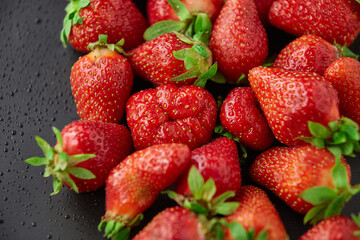 Strawberry on a black background with raindrops very fresh bright open diaphragm attractive advertising hunt buy in a hurry