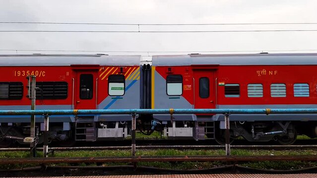 indian passenger express train crossing station on track at evening from flat angle
